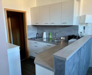 a kitchen with white cabinets and a counter top at Blue Max Parkzimmer in Großenhain