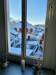 a window with a view of a snow covered city at Blue Max Parkzimmer in Großenhain
