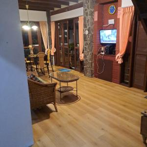 a living room with a table and a tv at Villa Elisabeth at Villa Istana Bunga in Bandung