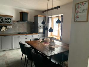 a kitchen with a wooden table and some chairs at Hiša Pod gorami II****-house with wellness in Kranjska Gora