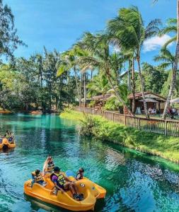 un grupo de personas en una balsa amarilla en el agua en un complejo en Farmhouse Miami en Miami