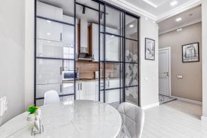 a white dining room with a table and chairs at Апартаменты в районе Экспо in Taldykolʼ +6 photos