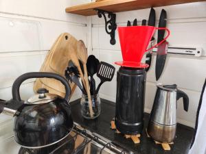 a kitchen counter with utensils on a counter top at Floripa Guest House in Florianópolis