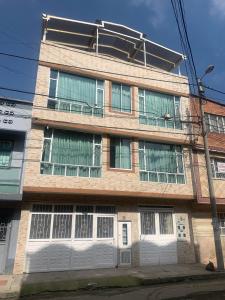 un edificio de apartamentos con puertas y ventanas blancas en Confortable Apartaestudio, en Bogotá
