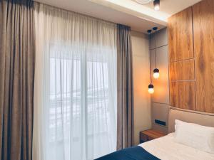 a bedroom with a bed and a large window at New Gudauri Premium Apartments NEO in Gudauri