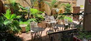 a patio with chairs and tables in a garden at Durban Shores Holiday Apartments in Durban