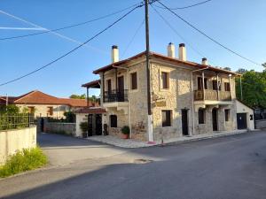 una vieja casa de piedra al lado de una calle en Archontiko Nikolopoulou, en Vitina