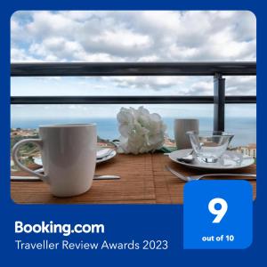 a table with a coffee cup and aucer on a balcony at Reed´s View in Caniço