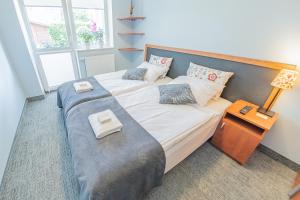 a bedroom with two beds and a lamp in it at Willa Szafir in Kołobrzeg