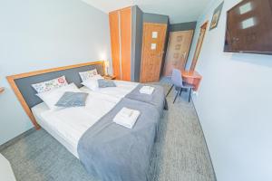 a bedroom with a bed and a table and a chair at Willa Szafir in Kołobrzeg