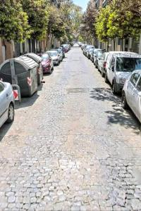 a cobblestone street with cars parked on both sides at Alex- DUPLEX APARTMENT- City in Valencia