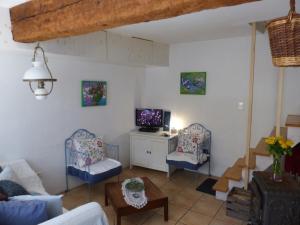 a living room with two chairs and a tv at Maison des Remparts nichée sous la Cité in Carcassonne