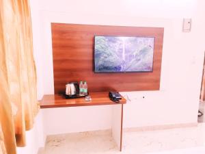 Keerthis Royal Suites - Near International Airport Terminal 1 and 2的电视和/或娱乐中心