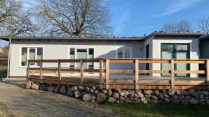 una casa con una valla de madera delante de ella en Ferienhaus Saphir - Vor der Küste Boltenhagens barrierefreies Haus, en Damshagen