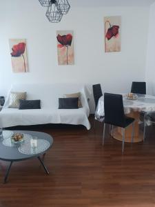 ein Wohnzimmer mit einem Sofa und einem Tisch in der Unterkunft Le Saint Max in Saint-Max