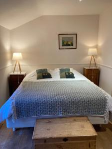 um quarto com uma cama com um edredão azul e 2 candeeiros em Auberge du Val d'Aisne em Fanzel