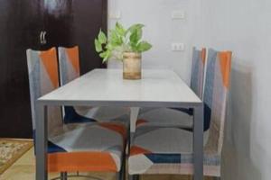 uma mesa e cadeiras com uma planta em vasos em 5 - Cabanatuan City's Best Bed and Breakfast Place em Cabanatuan