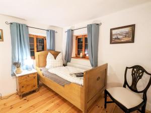 1 dormitorio con 1 cama, 1 silla y ventanas en Familienurlaub im gemütlichen Umgebindehaus, Seminarhaus, en Cunewalde