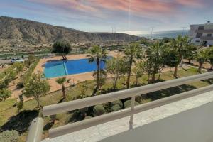 - un balcon avec des palmiers offrant une vue sur la piscine dans l'établissement Appartement vue sur piscine et sur mer, à Taghazout