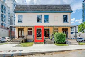 a house with a red door on a street at Airy and Bright on Broadway in Nashville