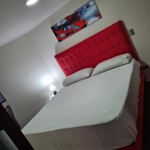 een slaapkamer met een groot bed met een rood hoofdeinde bij San Andres Suite Apartments in Santiago