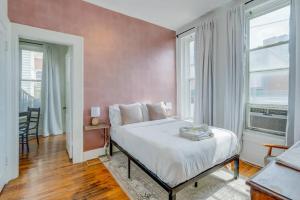 a bedroom with a large bed and a pink wall at Apartment on Broadway in Nashville