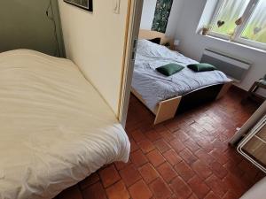 Dormitorio pequeño con cama y espejo en Bienvenue du côté de chez nous en Wignehies