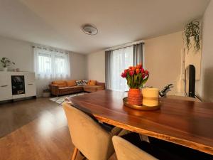 una sala de estar con una mesa de madera con flores. en Ferienwohnung Natur, en Balingen