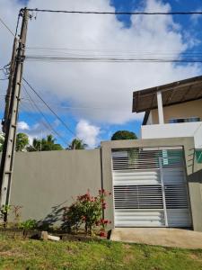 una puerta de garaje al lado de una casa en Casapraiacururupe en Ilhéus