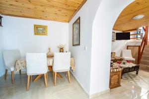 ein Esszimmer mit einem Tisch, Stühlen und einem Bett in der Unterkunft Maria House in Karpathos