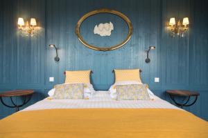 a bedroom with a large bed with blue walls at Domaine Utah Beach - Le Grand Hard in Sainte-Marie-du-Mont