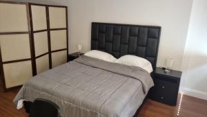 um quarto com uma cama grande e 2 almofadas em CCCT ApartaHotel Ccct em Caracas