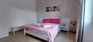 um quarto com uma cama rosa e almofadas cor-de-rosa em B&B Villa Noemi em Porto Cesareo