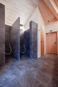 Habitación grande con ducha y puerta de madera. en Haus Sonnblick b&b en Stuben am Arlberg