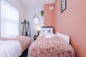 a bedroom with two beds with hats on them at Trendy house, close to stadiums, free wifi and car park in Liverpool