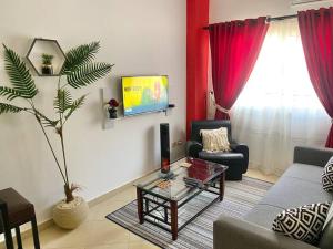 New cozy apt. on the promenade في الغردقة: غرفة معيشة مع أريكة وتلفزيون