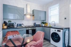 a kitchen with a table and a washing machine at Trendy house, close to stadiums, free wifi and car park in Liverpool
