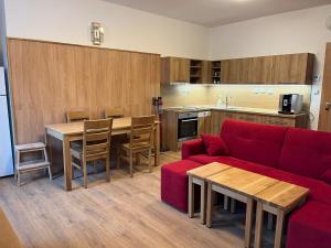 uma sala de estar com um sofá vermelho e uma cozinha em Apartmány Nýdečanka em Nýdek