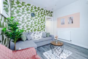 a living room with a blue couch and a geometric wall at Trendy house, close to stadiums, free wifi and car park in Liverpool