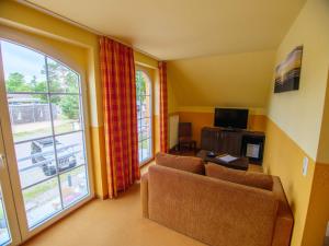 sala de estar con sofá y ventana grande en Hotel Strandburg Prerow en Prerow