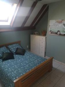 - une chambre avec un lit et un van sur le mur dans l'établissement Le Plouf des Gargouilles, à Onet le Château