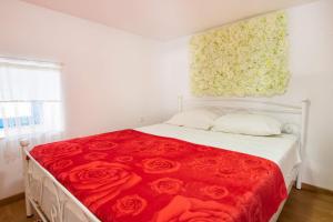 um quarto com uma cama com lençóis vermelhos e rosas em Maria House em Cárpatos