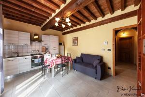 cocina con mesa y sofá azul en una habitación en Appartamento Sole-Luna, en Colleoli
