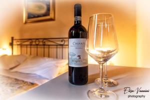 Colleoli的住宿－Appartamento Sole-Luna，葡萄酒杯旁的一瓶葡萄酒