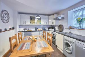 una cocina con mesa de madera y sillas. en Cosy Cumbrian cottage for your country escape, en Brough