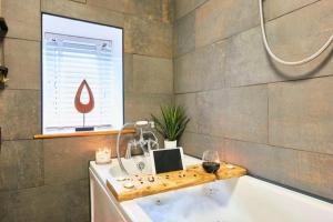 baño con bañera, ventana y lavamanos en Cosy Cumbrian cottage for your country escape en Brough