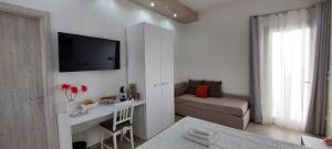 uma pequena sala de estar com um sofá e uma televisão em B&B Villa Noemi em Porto Cesareo