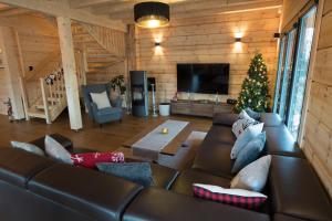 a living room with a couch and a christmas tree at Vila Lomnica Vysoké Tatry in Veľká Lomnica