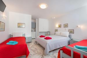 a bedroom with two beds with red sheets at Irene Rooms Naousa Parou in Naousa