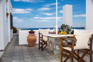 a table and chairs on a balcony with a view of the ocean at Irene Rooms Naousa Parou in Naousa